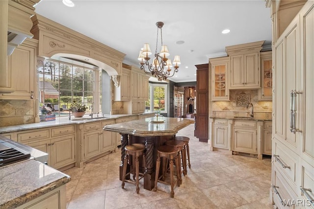 21 Log Cabin Dr, Saint Louis, MO 63124 - kitchen with cream cabinetry, a sink, tasteful backsplash, a chandelier, and light stone countertops