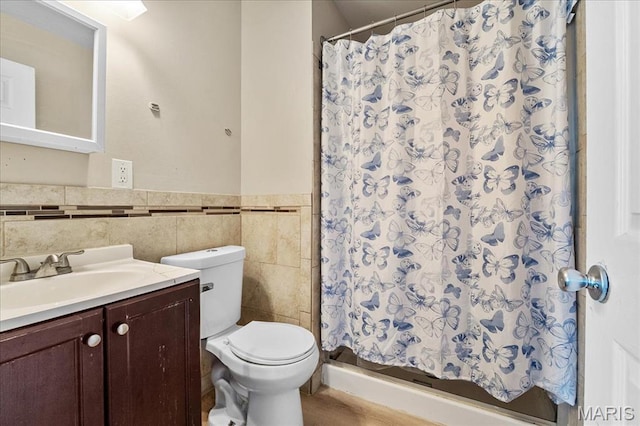 4321 E Fairfax Ct, Saint Louis, MO 63113 - full bathroom featuring tile walls, toilet, vanity, a stall shower, and wainscoting