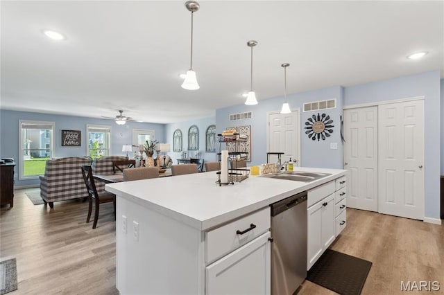 104 Tiber Way, Saint Charles, MO 63301 - kitchen featuring dishwasher, a sink, white cabinets, decorative light fixtures, and light wood-style flooring