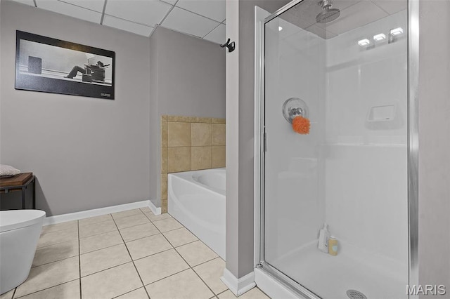 bathroom with a stall shower, tile patterned flooring, a garden tub, and baseboards