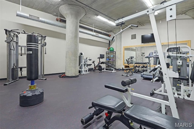 exercise room featuring a towering ceiling