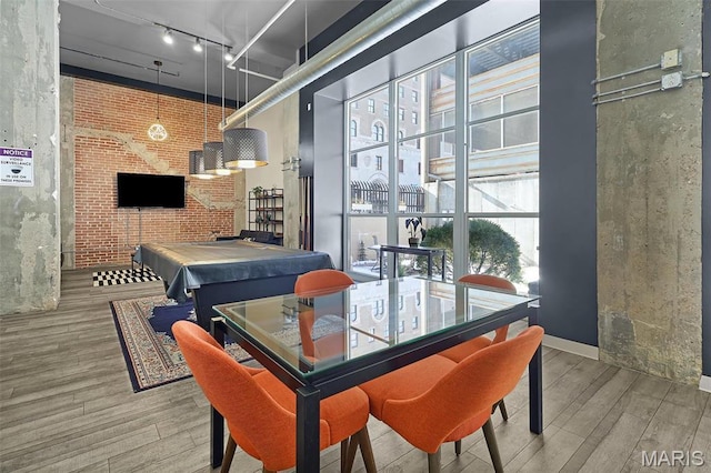 dining space featuring wood finished floors, billiards table, a high ceiling, and track lighting