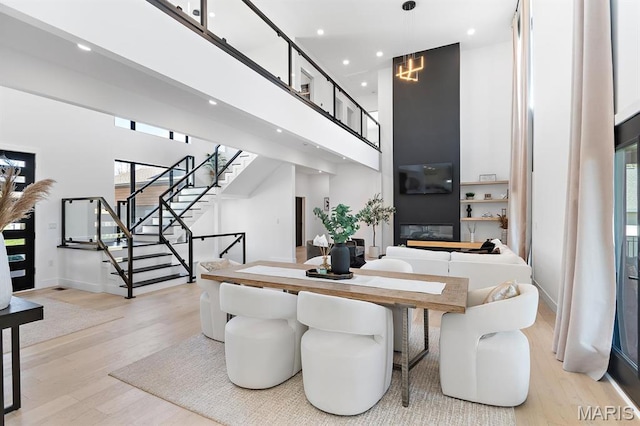 10010 Schuessler Rd, Saint Louis, MO 63128 - dining room with stairs, light wood-type flooring, recessed lighting, a high ceiling, and baseboards