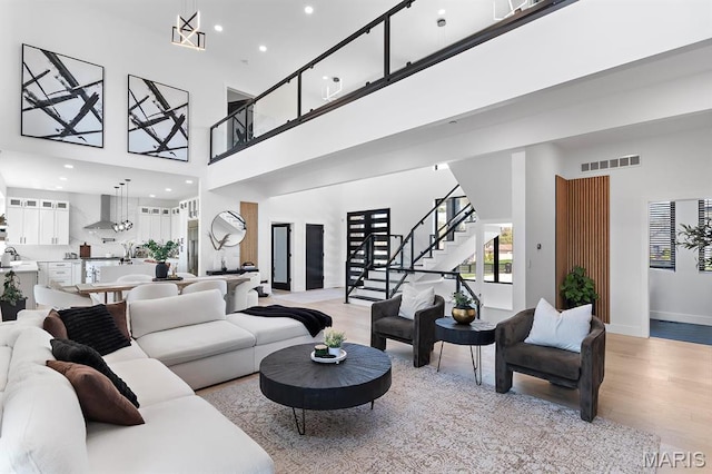 10010 Schuessler Rd, Saint Louis, MO 63128 - living area with light wood finished floors, stairway, a towering ceiling, recessed lighting, and baseboards