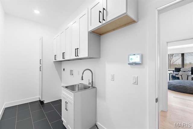 10010 Schuessler Rd, Saint Louis, MO 63128 - laundry room featuring hookup for a washing machine, hookup for an electric dryer, cabinet space, baseboards, and dark tile patterned flooring