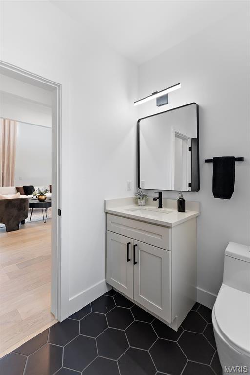 10010 Schuessler Rd, Saint Louis, MO 63128 - bathroom with baseboards, toilet, and vanity