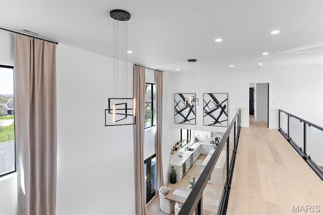 10010 Schuessler Rd, Saint Louis, MO 63128 - hallway with light wood-style flooring, recessed lighting, and an upstairs landing