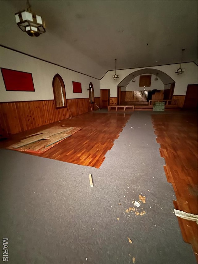 5920 County Rd 20, Belleview, MO 63623 - interior space with arched walkways, a wainscoted wall, wooden walls, wood finished floors, and vaulted ceiling