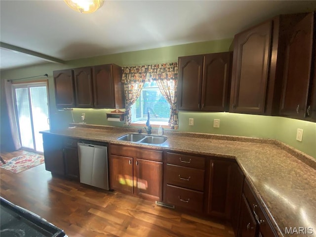 kitchen with dishwasher, a sink, dark wood-style floors, and light countertops
