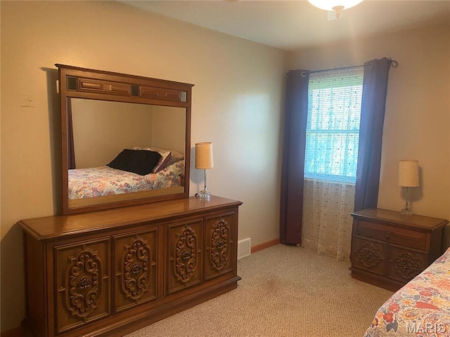 bedroom featuring light colored carpet and baseboards