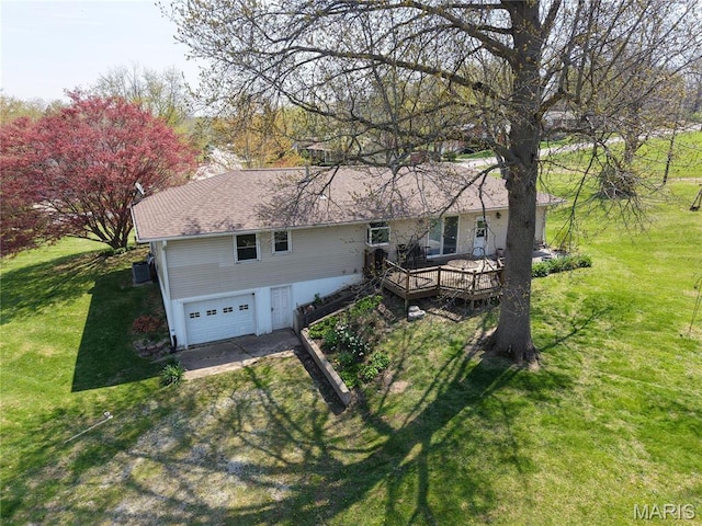 view of front facade featuring an attached garage, driveway, a front lawn, and a wooden deck