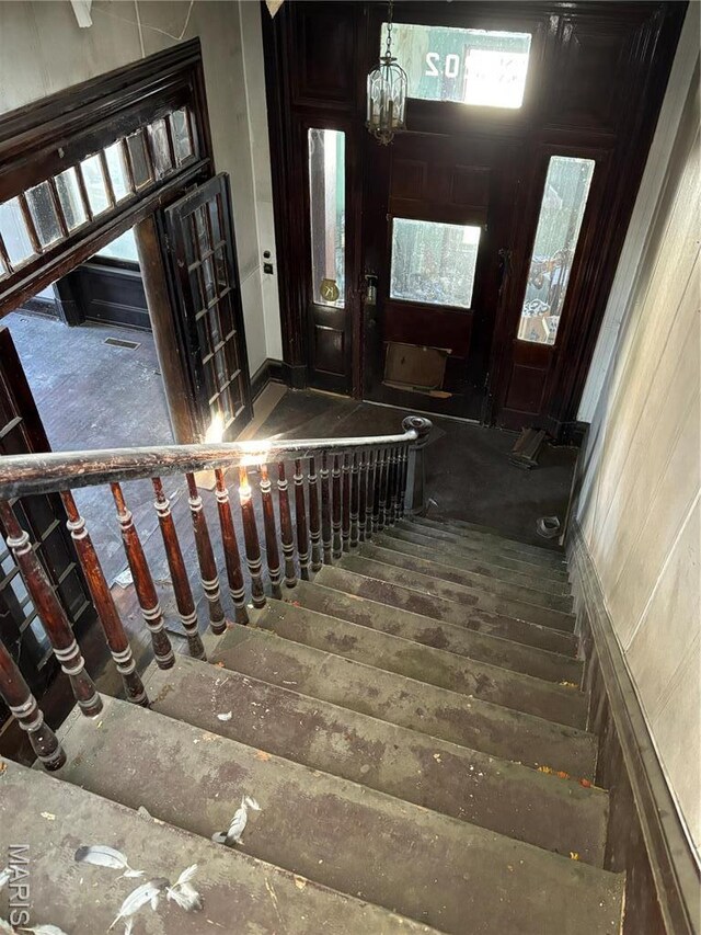 staircase with a chandelier