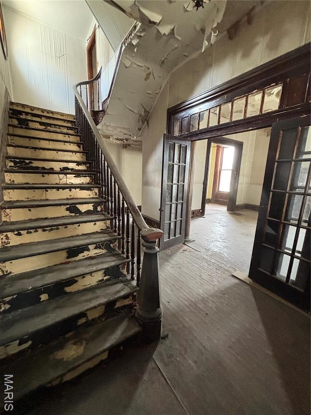 stairway featuring a high ceiling and wood finished floors
