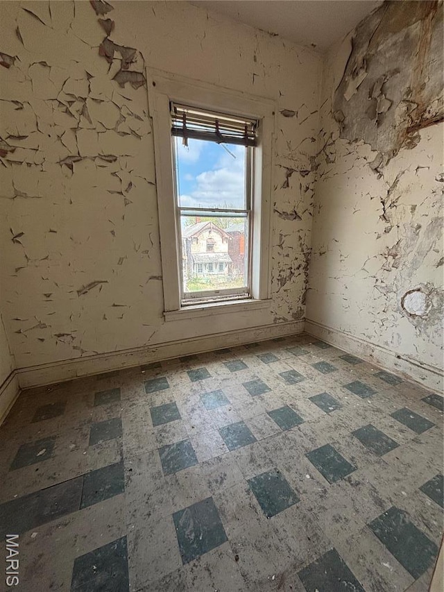 spare room featuring tile patterned floors and baseboards
