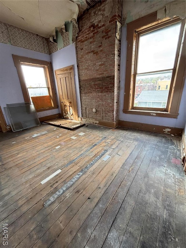 unfurnished room with healthy amount of natural light and hardwood / wood-style flooring