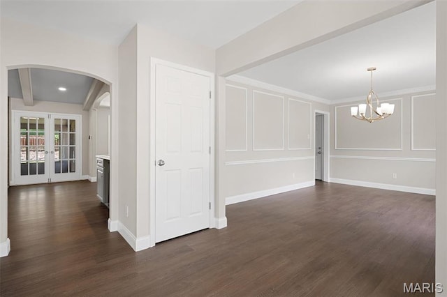 362 Hibler Ct, Saint Louis, MO 63141 - spare room featuring arched walkways, dark wood-style floors, a chandelier, a decorative wall, and baseboards