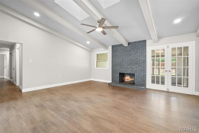 362 Hibler Ct, Saint Louis, MO 63141 - unfurnished living room with a skylight, a ceiling fan, wood finished floors, a fireplace, and baseboards