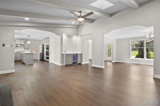 362 Hibler Ct, Saint Louis, MO 63141 - unfurnished living room with beverage cooler, ceiling fan, arched walkways, dark wood finished floors, and baseboards