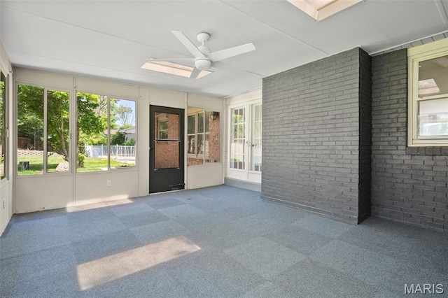 362 Hibler Ct, Saint Louis, MO 63141 - unfurnished sunroom featuring a ceiling fan, carpet floors, brick wall, a skylight, and french doors