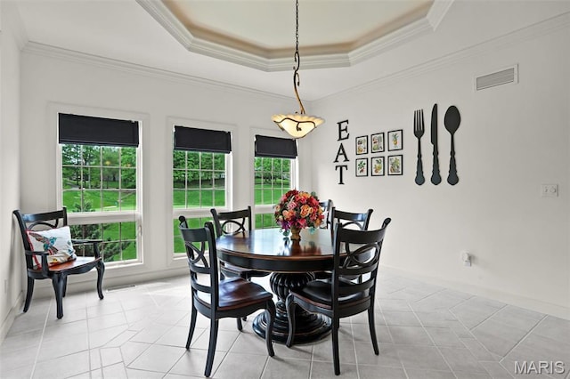 dining room featuring a tray ceiling, crown molding, baseboards, and light tile patterned floors
