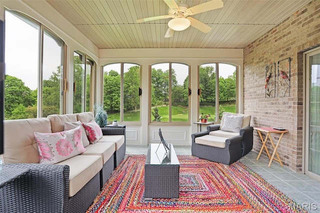sunroom featuring ceiling fan, outdoor lounge area, tile patterned floors, brick wall, and wood ceiling