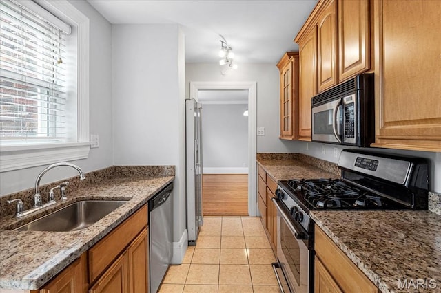 7570 Byron Pl Unit 3W, Saint Louis, MO 63105 - kitchen with stainless steel appliances, a sink, light tile patterned floors, and dark stone countertops
