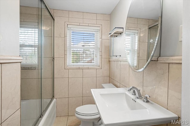 7570 Byron Pl Unit 3W, Saint Louis, MO 63105 - full bathroom with tile walls, toilet, plenty of natural light, shower / bath combination with glass door, and a sink