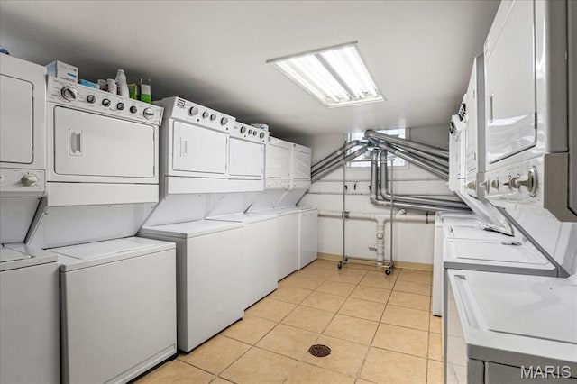 7570 Byron Pl Unit 3W, Saint Louis, MO 63105 - community laundry featuring stacked washer and clothes dryer, light tile patterned floors, and baseboards