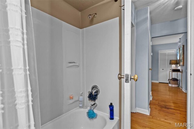 5872 Sunshine Dr Unit 110, Saint Louis, MO 63109 - bathroom featuring wood finished floors, shower / washtub combination, and baseboards