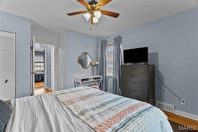 5872 Sunshine Dr Unit 110, Saint Louis, MO 63109 - bedroom featuring multiple windows, wood finished floors, baseboards, and a ceiling fan
