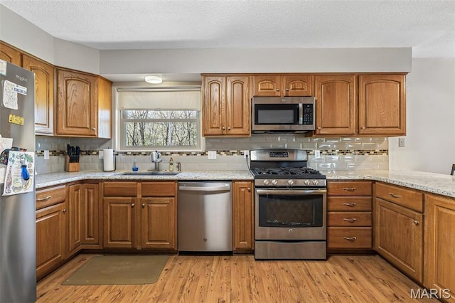 13145 Wanda Lee Ln, Saint Genevieve, MO 63670 - kitchen with stainless steel appliances, a sink, brown cabinets, and a textured ceiling