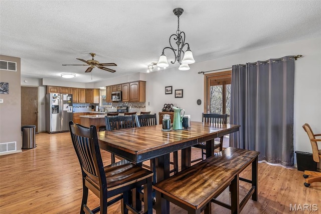 13145 Wanda Lee Ln, Saint Genevieve, MO 63670 - dining space with light wood finished floors, a ceiling fan, a textured ceiling, and a chandelier