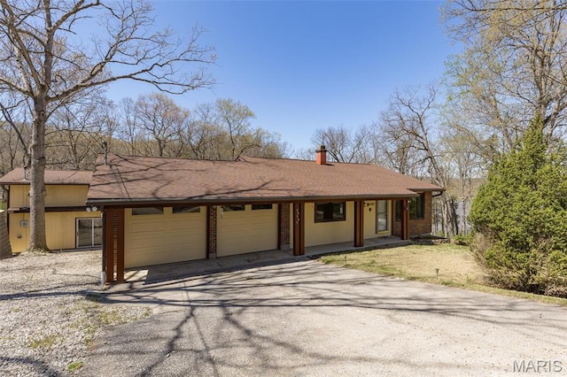13145 Wanda Lee Ln, Saint Genevieve, MO 63670 - view of front of home featuring a garage, asphalt driveway, brick siding, and a chimney