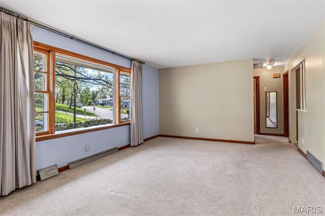 8907 Spur Ln, Saint Louis, MO 63121 - carpeted empty room featuring a baseboard radiator, plenty of natural light, and baseboards