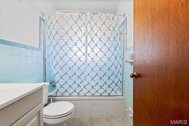 8907 Spur Ln, Saint Louis, MO 63121 - full bathroom with tile walls, shower / bath combo with shower curtain, vanity, toilet, and wainscoting