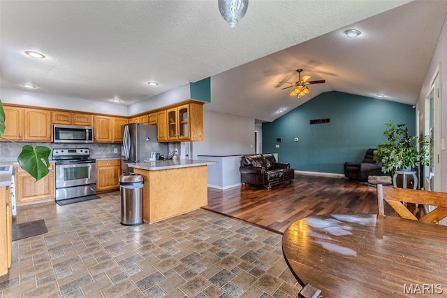 20373 Heritage Rd, Saint Robert, MO 65584 - kitchen featuring appliances with stainless steel finishes, ceiling fan, open floor plan, glass insert cabinets, and light countertops