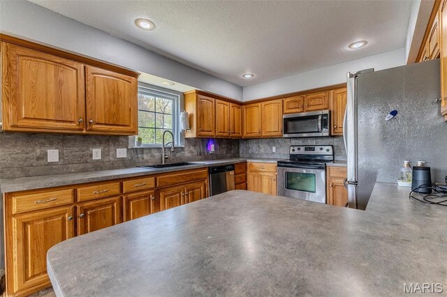 20373 Heritage Rd, Saint Robert, MO 65584 - kitchen with stainless steel appliances, a sink, decorative backsplash, brown cabinetry, and a textured ceiling