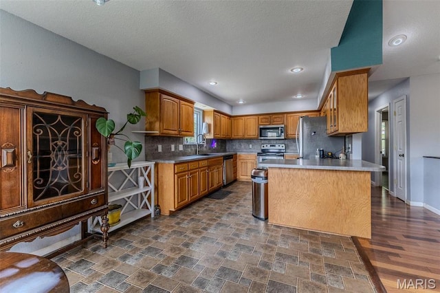 20373 Heritage Rd, Saint Robert, MO 65584 - kitchen with appliances with stainless steel finishes, tasteful backsplash, a peninsula, dark stone finish floors, and a textured ceiling