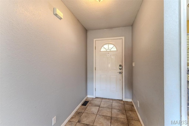20373 Heritage Rd, Saint Robert, MO 65584 - doorway featuring a textured ceiling, light tile patterned flooring, baseboards, and a textured wall