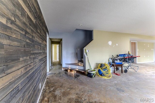 20373 Heritage Rd, Saint Robert, MO 65584 - living area featuring unfinished concrete floors, a textured ceiling, and wooden walls