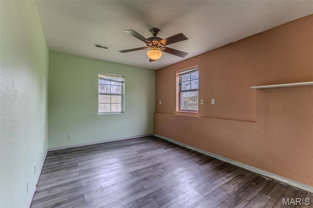 20373 Heritage Rd, Saint Robert, MO 65584 - unfurnished room with healthy amount of natural light, ceiling fan, wood finished floors, baseboards, and a textured wall