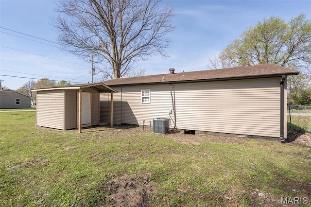 back of house featuring a lawn, a shed, crawl space, an outbuilding, and cooling unit