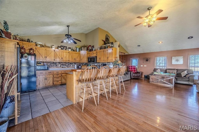 10530 Aspen Rd, Conway, MO 65632 - kitchen featuring a ceiling fan, freestanding refrigerator, vaulted ceiling, open floor plan, and light wood-type flooring