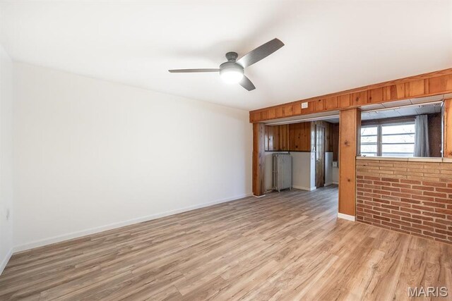 10 Hill Dr, Fairview Heights, IL 62208 - unfurnished living room featuring light wood-style floors, ceiling fan, baseboards, and radiator heating unit