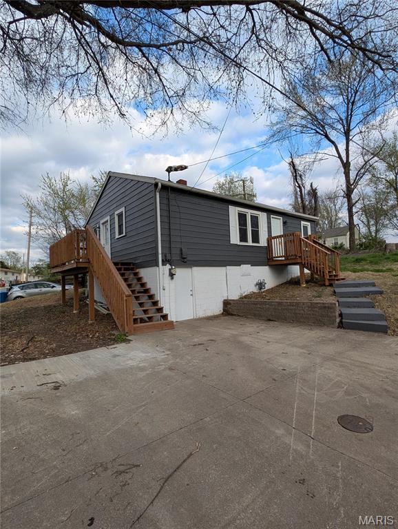 back of property with stairway and a wooden deck