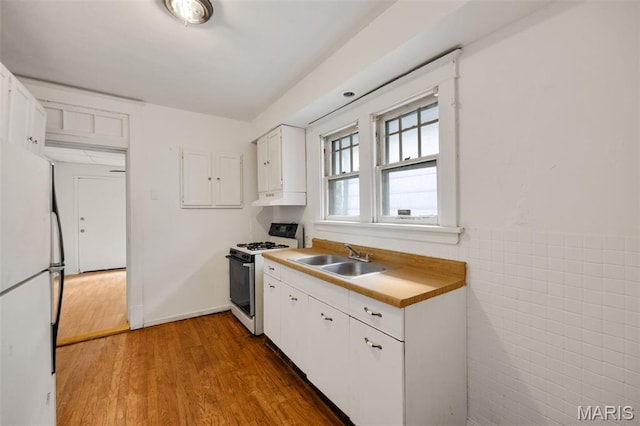 5923 Sherry Ave, Saint Louis, MO 63136 - kitchen featuring white appliances, a sink, white cabinets, wood finished floors, and tile walls