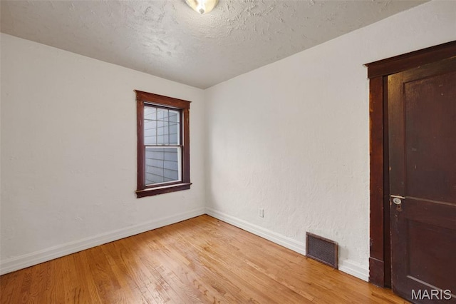 5923 Sherry Ave, Saint Louis, MO 63136 - spare room with baseboards, light wood-type flooring, and a textured ceiling