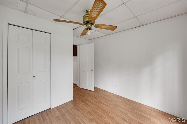 5923 Sherry Ave, Saint Louis, MO 63136 - unfurnished bedroom with light wood-type flooring, a closet, a ceiling fan, baseboards, and a paneled ceiling