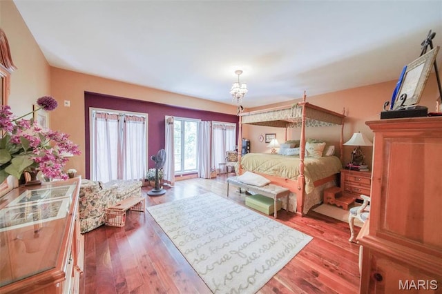 bedroom featuring a chandelier and wood finished floors