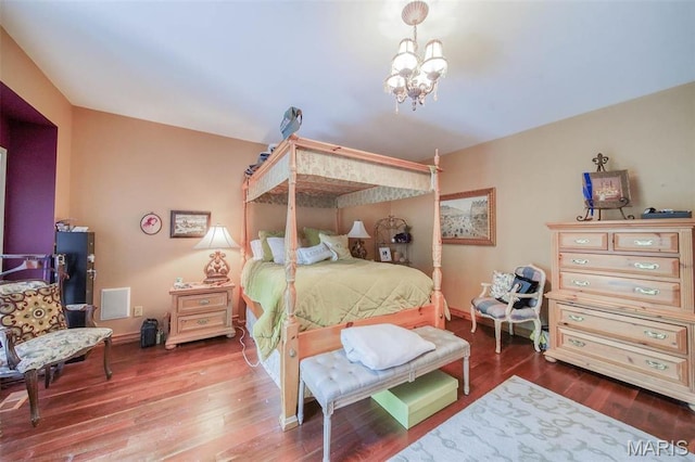 bedroom with a chandelier and wood finished floors